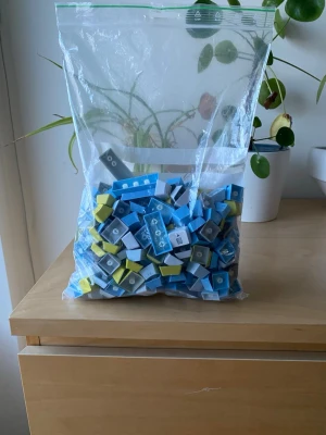 Stor påse med tangentbordsknappar - En stor zip-påse fylld med tangentbordsknappar i blått, grått, vitt och gult. Knapparna har olika former och symboler, vissa med text och ikoner. Perfekt för dig som vill byta ut eller bygga om ditt tangentbord med unika färger och stilar.