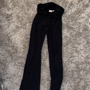Marinblåa bootcut byxor Gina Tricot - Marinblåa yoga pants byxor från Gina Tricot med låg midja. Byxorna har en snygg, figurnära passform upptill och vida ben nertill. Perfekta för dig som gillar en stilren och trendig look.
