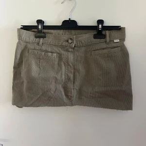 Kakigrön kortkjol - Säljer en beige kortkjol i manchester liknande typ.Perfekt att matcha med sneakers eller boots. Snygg och enkel design som funkar året runt. Kjolen är lite mer kaki krön i verkligheten det har svårt att få med färgen på bild men det är den perfekta färgen inför hösten. 