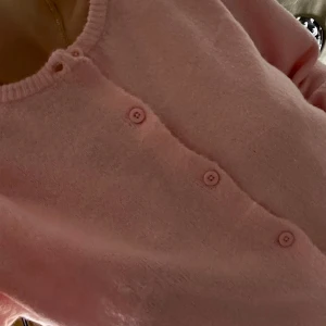 Ljusrosa kofta med knappar - Supermysig ljusrosa kofta med rund hals och matchande rosa knappar framtill. Koftan är stickad och har en mjuk, fluffig känsla som gör den perfekt för kyliga dagar. Enkel och söt design som är lätt att styla med dina favoritjeans eller kjol.