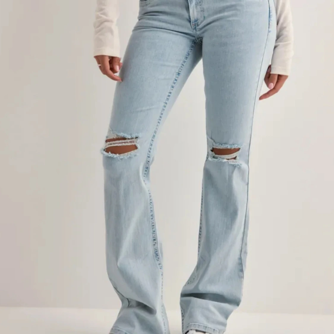 Ljusblå bootcut jeans med slitningar