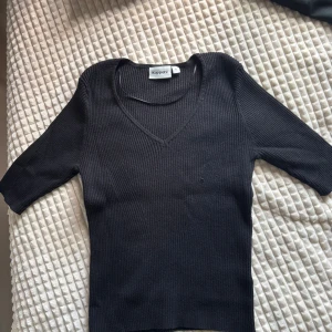 Svart ribbad tröja från Kappahl - Svart ribbad tröja från Kappahl med v-ringning och trekvartsärm. Tröjan har en slim passform och är tillverkad i ett mjukt, stickat material som sitter snyggt på kroppen. Jag bär vanligtvis storlek xs/s men denna satt tajt också. Pris går att diskutera.