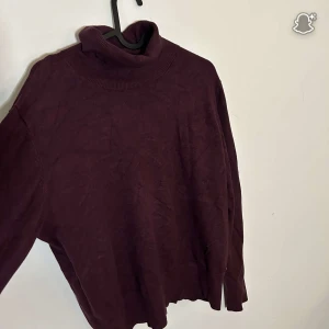 Vinröd polotröja Holly & Whyte XL - Mysig vinröd polotröja från Holly & Whyte i storlek XL. Tröjan är stickad med lång ärm och har snygga knappar vid ärmsluten. Perfekt för kyliga dagar och enkel att matcha med jeans eller kjol.