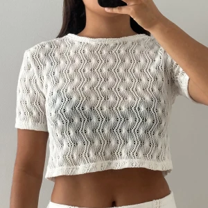 Vit stickad croppad topp - Superfin vit stickad croppad topp med korta ärmar och ett unikt virkat mönster. 