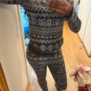 Mörkgrå byxa och tröja - Säljer båda två samtidigt.Mysig mörkgrå långärmad tröja med vita snöflingor, hjärtan och zigzag-mönster. 