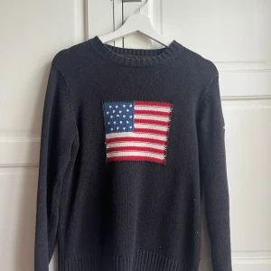 Stickad blå tröja med USAs flagga - Hejjjj säljer min stickade mörkblåa tröja ifrån gant med USAs flagga på eftersom att den inte kommer till användning. Passar både killar och tjejer. Passar mig som är XS