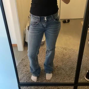 flared jeans - lågmidjade blåa flared jeans från hm med knappfickor på baksidan. de är använda men har varit väl omhändertagna, finns inga slitningar eller hål. säljer för de ej kommer till användning.