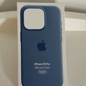 Blått iPhone 15 Pro Apple silikonfodral - Snyggt blått silikonfodral till iPhone 15 Pro från Apple. Fodralet har en stilren design med Apple-logga på baksidan och är kompatibelt med MagSafe. Ger ett bra grepp och skyddar mobilen utan att kännas klumpig. Perfekt för dig som vill ha en clean look. Liten spricka men inte synlig från långt avstånd.