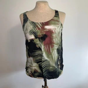 Tre överdelar  - Bild 1: Linne från Kappahl storlek XS. Bild 2: Skjorta med abstrakt mönster från monki storlek S. Bild 3: Skjorta med blommor, står inget märke men storlek S