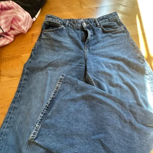 Blå wide jeans från Zara - Säljer ett par blå jeans från Zara i storlek 34. Modellen har en loose och wide passform med klassisk femficksdesign och hög midja. Jeansen är tillverkade i jeansmaterial och har knapp och dragkedja framtill. Perfekta för en chill och trendig look.