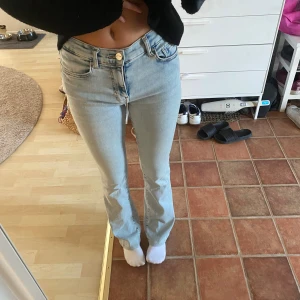 Ljusblå raka jeans med låg midja från bikbok  - Säljer ett par ljusblå jeans med låg midja och raka ben. Jeansen har klassisk femficksdesign, gylf med dragkedja och knapp samt snyggt tvättad denim. Perfekta för en avslappnad look från bikbok aldrig använda