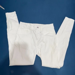 Vita skinny jeans  - Snygga vita skinny jeans från bikbok med silverfärgad knapp. En liten fläck framtill som man kan se i sista bilden