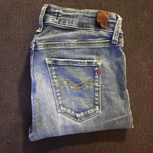 Replay jeans ljusblå, W27 L30 - Säljer ett par snygga skinny jeans från Replay i ljusblå tvätt med slitningar och klassiska femficksdetaljer. Jeansen har låg midja och smal passform, perfekt för dig som gillar en tight look. Materialet är mjukt och stretchigt för extra komfort.