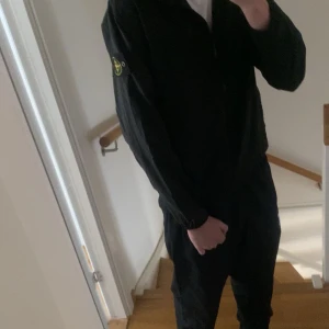 Svart vindjacka från Stone Island - Svart vindjacka från Stone Island med klassisk logotyp på vänster ärm. Bra skick, skriv om du har funderingar!