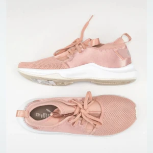 Rosa sneakers från Puma med mesh - Snygga sneakers från Puma i en ljusrosa ton med vit sula. Ovandelen är i mesh och syntet, vilket ger en sportig vibe. Skorna har snörning och Puma-logga baktill. Perfekta för dig som gillar stilrena och bekväma sneakers med modern känsla.