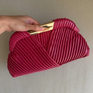 Kuvertväska från Zara i skinn - Kuvertväska från Zara i skinn med plisserad design och guldfärgad metallram upptill. 