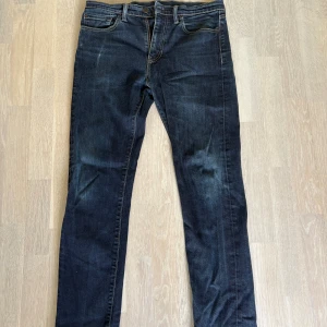 Levi's 522 mörkblå jeans straight fit - Mörkblå Levi's 522 jeans med klassisk femficksdesign och rätt slim ben. Jeansen har snygga slitningar och kontrastsömmar. Tillverkade i robust denim som ger en cool och tidlös look. Perfekta för dig som gillar en enkel och stilren stil.
