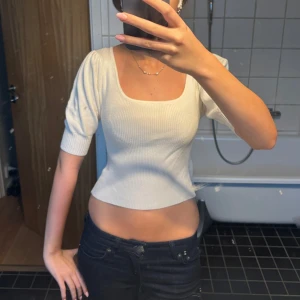 Vit ribbad topp - Säljer en vit  topp med fyrkantig ringning och puffiga halvlånga ärmar. Toppen är ribbad och sitter tight, perfekt till jeans eller kjol. Endast använd en gång. Pris går att diskuteras