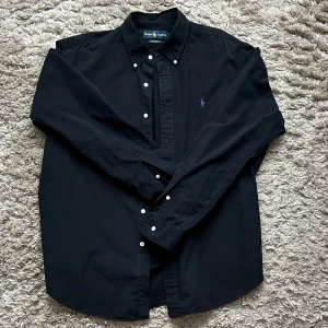 Svart skjorta från Ralph Lauren - Hej! ✨ Säljer nu min extremt snygga och eftertraktade skjorta från märket Ralph Lauren till ett oslagbart pris. Skjortan är i väldigt fint skick. Skriv vid funderingar!