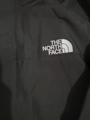 Svart vindjacka från The North Face - Säljer en svart vindjacka från The North Face med huva och dragkedja framtill. Perfekt för blåsiga dagar och enkel att matcha med allt.