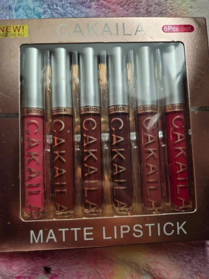 CAKAILA 6-pack matta läppstift - Säljer ett set med 6 matta läppstift från CAKAILA. Färgerna varierar från rosa, röd, vinröd till olika bruna nyanser. Förpackningen är elegant i roséguld och varje läppstift har en silvrig kork och genomskinlig tub som visar färgen. Perfekt för dig som gillar matta läppar.