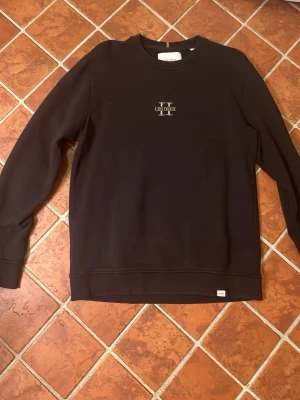 Svart sweatshirt från Les Deux  - Säljer en svart sweatshirt från Les Deux med logga broderad på bröstet. Tröjan har rund hals, långa ärmar och ribbade muddar. Inga defekter och pris kan diskuteras 