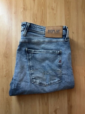 Replay Anbass jeans - Säljer ett par Replay Anbass jeans i klassisk blå tvätt. Jeansen har snygga slitningar och tillverkade i ekologisk bomull. Midja 48cm, längd 105cm. JAG SKICKAR EJ FLER BILDER NÄR JAG BÄR JEANSEN! för bättre inblick i passformen rekommenderar jag att googla på modellnamnet. För storleksguide kolla måtten noggrant då jeansen alltid kan vara uppsydda heller krympta och jag ej tar emot returer :) 1,14