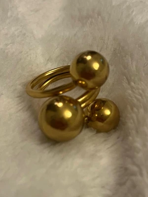 Guldig statementring✨ - Trendig guldfärgad ring med dekorativa kulor i olika storlekar som ger ett lekfullt men stilrent uttryck ✨ En perfekt statement-ring som sticker ut men ändå är lätt att matcha. ✨ Modern & trendig ✨ Unik kuldesign ✨ Statement men minimalistisk I mycket fint skick 🤍 Skickas snabbt 📦 Skriv gärna vid frågor eller om du vill ha fler bilder! #ring #guldring #statementring #trendigt #smycken #plick #aesthetic #fashion 