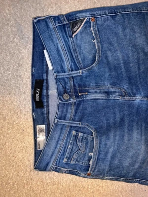 Replay Anbass jeans - Säljer ett par snygga Replay Anbass jeans. De är slitna i modellen vid fick öppninga. Dom är i storlek W29 och L32. Skicket är bra förutom att dom har ett hål över höger bakficka och några få trådar som sticker ut nere vid baksidan. Se på bilderna. Pris går att få ner.