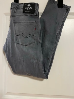 Replay jeans  - Säljer ett par riktigt snygga gråa anbass Replay jeans i slim fit. Jeansen har snygga detaljer på bakfickorna och en svart Replay-patch i midjan. Jeansen är i grå färg och storlek W31 L34. Knappt använda eftersom att de var lite för små när kag köpte dem.