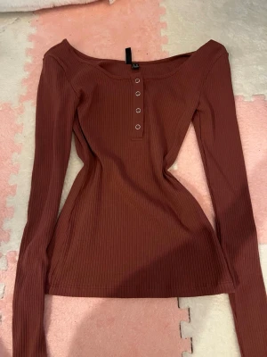 Rostbrun ribbad topp från Pieces - Säljer en ribbad långärmad topp från Pieces i en snygg rostbrun färg. 