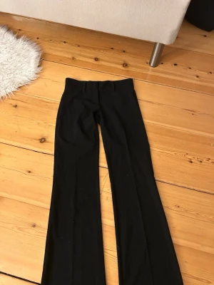 Svarta bootcut kostymbyxor från Nelly  - Tryck ej på köp nu!! Säljer ett par svarta bootcut byxor från Nelly i storlek 32. Byxorna har medel/låg midja och bootcut ben vilket ger en snygg siluett. Perfekta att styla med sneakers eller boots. Materialet känns mjukt och följsamt. Ordinarie pris 399!! Använda max 5 gånger, inget tecken på användning!