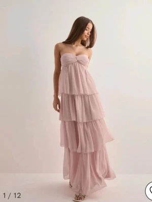 Ljusrosa långklänning med volanger - säljer min UNDERBARA balklänning från förra året! den säljs inte längre i denna färg från nelly utan i en starkare färg, så om man trivs mer i en mildare rosa är denna perfekt. det är en superfin ljusrosa balklänning med flera lager volanger och axelbandslös design. klänningen har en twistad detalj vid bysten och kan bäras både med och utan halterneckband. OBS: den är uppsydd för att passa mig som är lite kortare, går säkert att ta ner stygnen. kontakta för mer frågor! 🩷🩷 