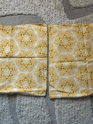 Gulvit mönstrade kuddfodral par H&M - Gulvit mönstrade kuddfodral i par. Bomullsmaterial och dragkedja. Storlek 50x50