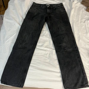 Svarta raka jeans från gina tricot - Säljer ett par svarta jeans från gina tricot med rak passform. Jeansen har en tidlös look med knappgylf. Perfekta för dig som gillar en clean och enkel stil.