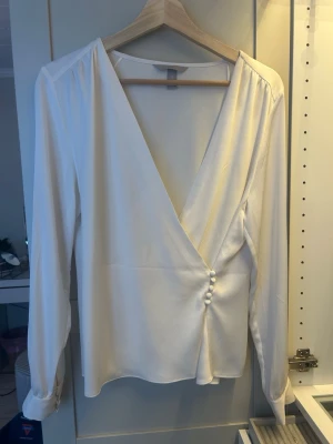 Vit blus från hm - En vit blus med v-ringning, gjord av silke liknande material passar perfekt för en fin middag. Men går också att styla till en vardags look perfekt för skolan.💞