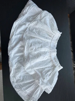 Vit volangkjol - Säljer denna vita volangkjol med spets ifrån BikBok. Den är aldrig använd🥰 Perfekt inför sommaren!