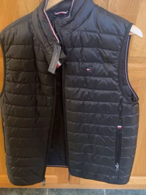 Svart dunväst från Tommy Hilfiger - Svart väst från tommyhillfiger. Aldrig använd, storlek M