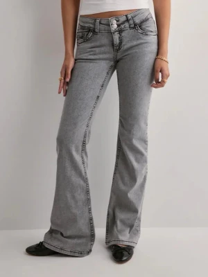 Grå Lågmidjade bootcut jeans - Snygga Lågmidjade grå jeans från Nelly, säljes för att dom ej kommer till användning. Jag sprängde en vattenfast eyeliner på jeansen, så darför har de streck. Dom är väldigt bra i storleken