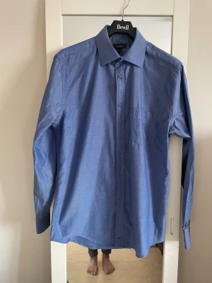 Blå skjorta från Riley, storlek M - Klassisk blå skjorta från Riley i storlek M. Skjortan har lång ärm, bröstficka och knappar framtill. Snygg krage och rak passform, perfekt till jeans eller chinos. Materialet 100%bomull  .har använd 3-4gånger helt ny nästa .har kostat 800kr 
