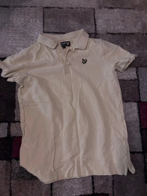 Gul Lyle&Scott piké - En ljus gul piké från Lyle&Scott. Den är i storlek junior.(12/13 years) Kontakta mig vid frågor!