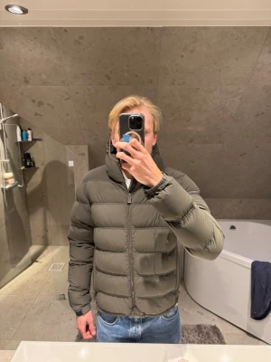 Mörkgrön pufferjacka från Aspesi - Säljer en mörkgrön pufferjacka från Aspesi med huva och dragkedja framtill. Storlek L men sitter mer som M skulle jag säga. Jag på bilden är 183 cm lång. Nypris för ett år sedan va 8000kr