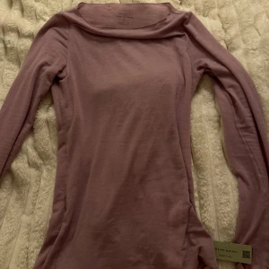 Ljuslila långärmad topp Intimissimi - Supersnygg ljuslila långärmad topp från Intimissimi i mjuk och tunn kashmirblandning. Enkel och stilren design med bredare halsringning och figurnära passform. Perfekt att styla med jeans eller kjol för en clean look.