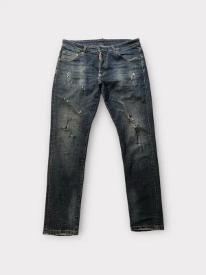 Dsquared2 blå distressed jeans - Ett par riktigt feta Dsquared 2 jeans men otroligt feta slitningar och synlig distress🔥storlek 50. Ytterbenslängd 100cm, midja 44, lårvidd 24cm, benöppning 15cm. Om ni har några funderingar är det bara att slå en pling!