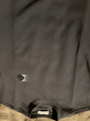 Svart sweatshirt från Moncler - Svart sweatshirt från Moncler i bomull med rund hals och ett coolt Moncler-emblem på bröstet med vit grafisk detalj. Tröjan har en clean look och passar perfekt till streetwear-stilen. Snygg att matcha med jeans eller joggers.