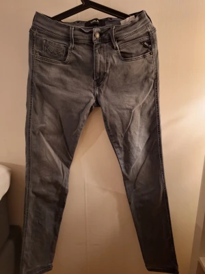 Replay grå jeans, waist 30/32 - Säljer ett par grå jeans från Replay i storlek 30/32. Jeansen har klassisk femficksdesign, raka ben och snygga detaljer på bakfickorna. Materialet är mjukt jeans-tyg och färgen är en tvättad grå nyans. Passar perfekt till en avslappnad stil.