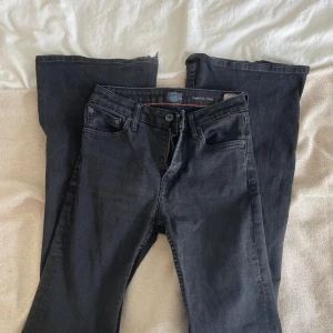 Svarta Crocker bootcut jeans 223 - Svarta jeans från Crocker, modell 223 Skinny Fit bootcut. Klassisk femficksdesign, dragkedjegylf och bekvämt tyg. Snyggt smal passform och diskreta detaljer. Perfekta för dig som gillar en stilren look med smala ben.