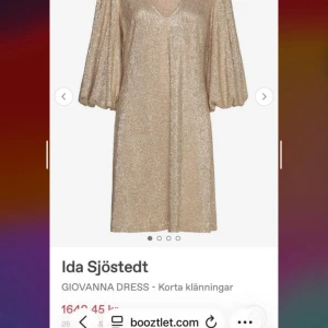 Glittrig kort klänning Ida Sjöstedt - Superfin glittrig kort klänning från Ida Sjöstedt i champagnefärg med v-ringning och vida trekvartsärmar. Perfekt för dig som vill sticka ut med en lyxig och trendig look. Materialet har en skimrande finish som fångar ljuset snyggt.