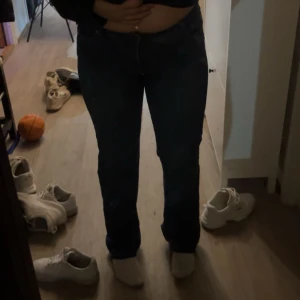 Mörkblå raka jeans - Säljer ett par mörkblå jeans med klassisk rak passform och normal midja. Jeansen  stängs med dragkedja och knapp. Perfekta för en clean och enkel look.