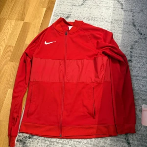 Ziptröja från Nike - Röd Ziptröja från Nike. Använd 2 gånger då den är stor. Storlek M. Vid snabb affär kan man komma med prisförslag.